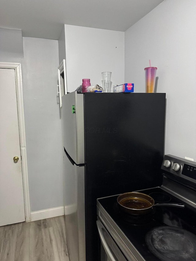 kitchen with stainless steel range with electric cooktop and light hardwood / wood-style floors