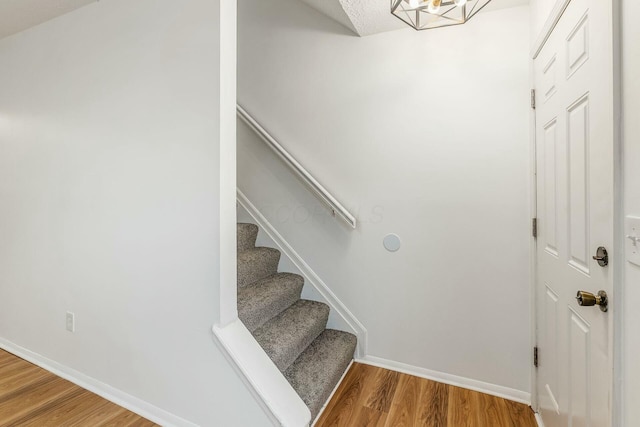 staircase with wood-type flooring and a textured ceiling