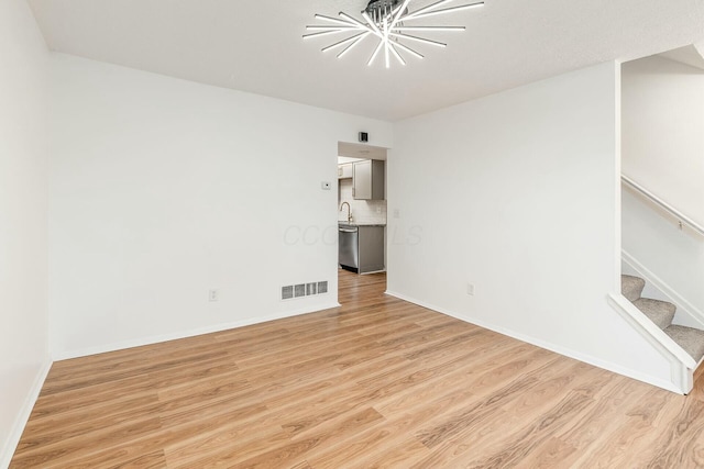 spare room featuring sink and light hardwood / wood-style floors