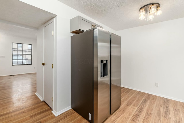 kitchen featuring gray cabinets, an inviting chandelier, a textured ceiling, stainless steel fridge with ice dispenser, and light wood-type flooring