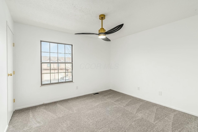 carpeted empty room featuring ceiling fan and a textured ceiling