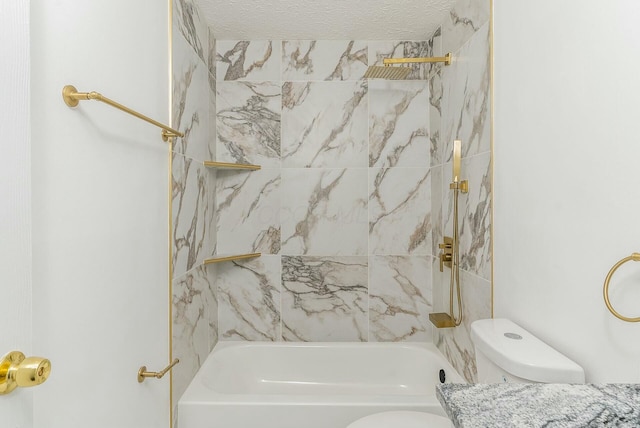 bathroom featuring tiled shower / bath combo, toilet, and a textured ceiling