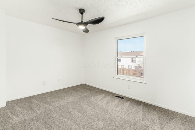 empty room featuring a textured ceiling, ceiling fan, and carpet