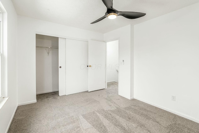 unfurnished bedroom with light carpet, ceiling fan, and a closet