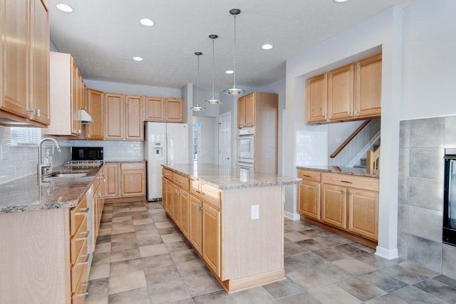 kitchen featuring sink, hanging light fixtures, white refrigerator with ice dispenser, a center island, and light stone countertops