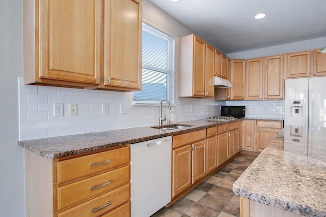 kitchen featuring sink, light brown cabinets, white appliances, light stone countertops, and decorative backsplash