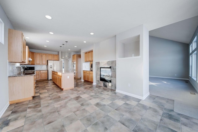 kitchen featuring a tile fireplace, decorative light fixtures, backsplash, a center island, and white fridge with ice dispenser