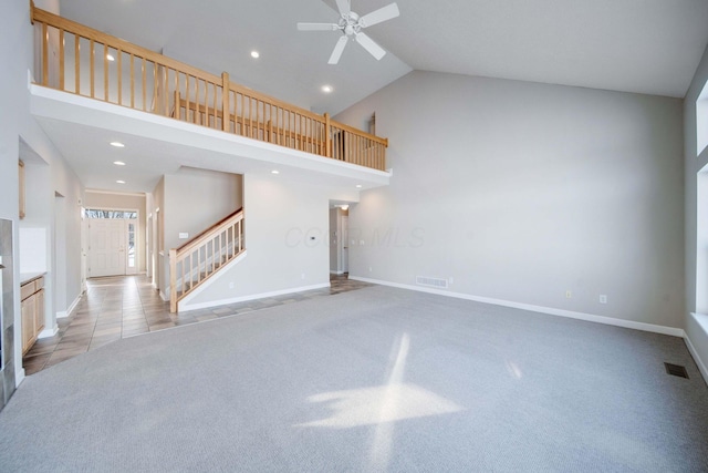 unfurnished living room featuring ceiling fan, high vaulted ceiling, and light carpet