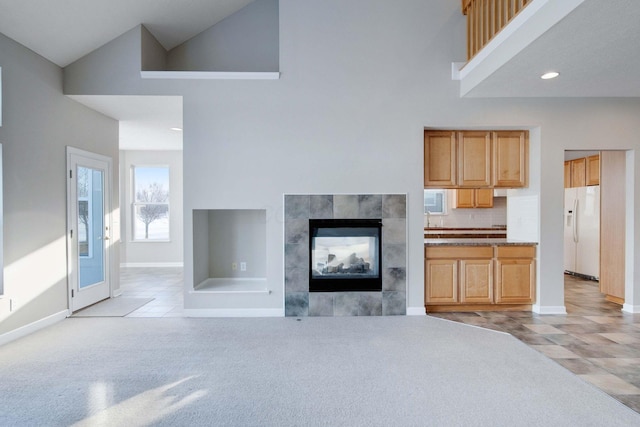 kitchen with high vaulted ceiling, a fireplace, tasteful backsplash, white refrigerator with ice dispenser, and light carpet