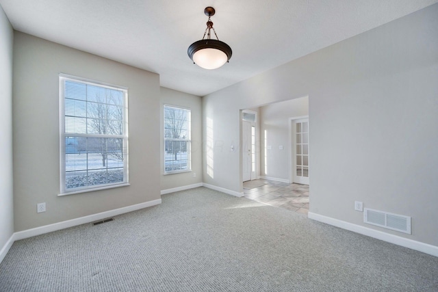 spare room featuring light carpet