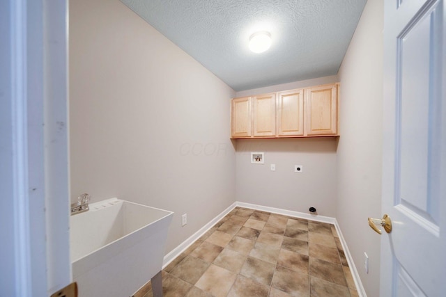 laundry room with sink, electric dryer hookup, hookup for a washing machine, cabinets, and a textured ceiling