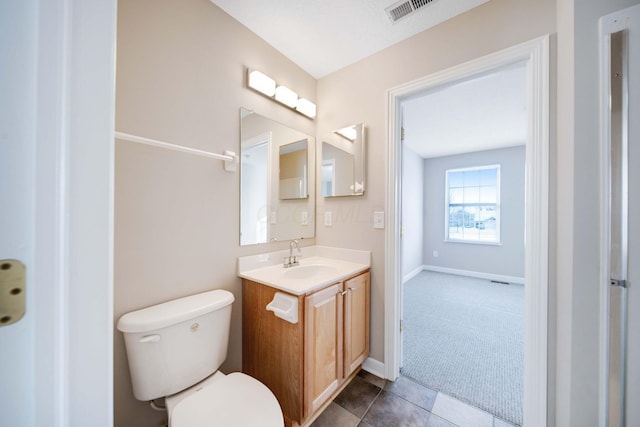 bathroom featuring vanity, tile patterned flooring, and toilet