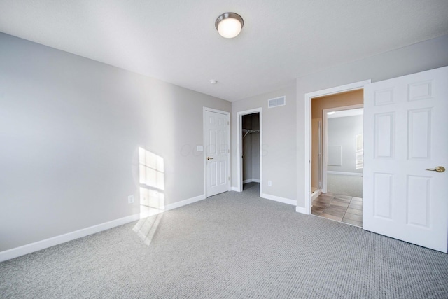 unfurnished bedroom featuring a closet, connected bathroom, and carpet