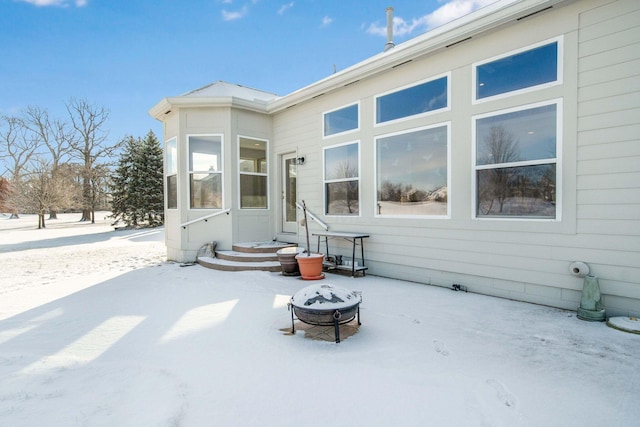 snow covered house featuring an outdoor fire pit