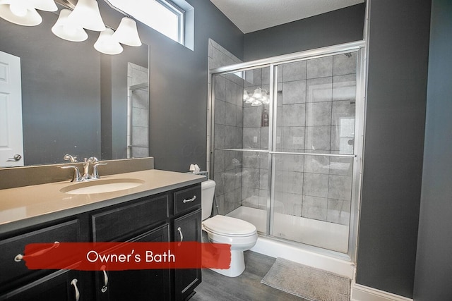 bathroom featuring vanity, toilet, and a shower with shower door