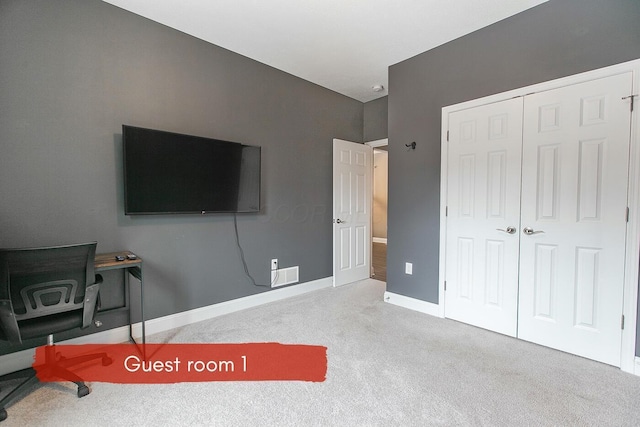 bedroom featuring light carpet and a closet