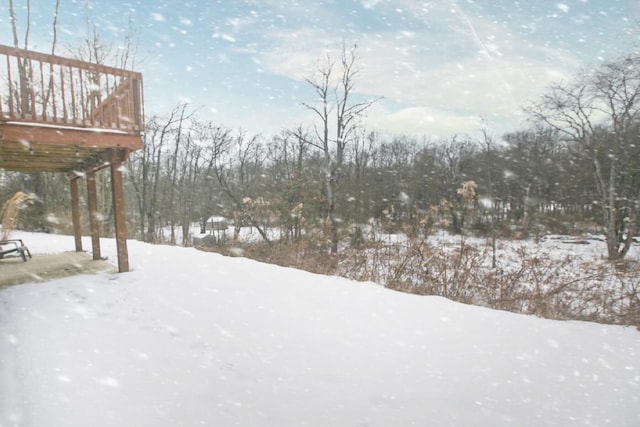 yard covered in snow with a wooden deck