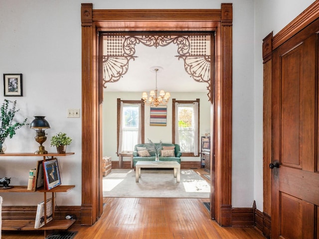 hallway featuring a chandelier and light hardwood / wood-style flooring