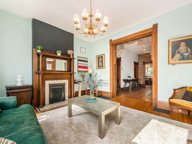 living room featuring a notable chandelier, hardwood / wood-style flooring, and a large fireplace