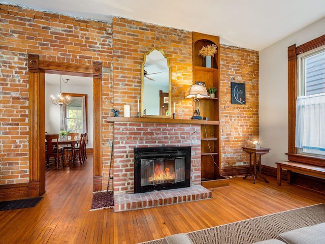 unfurnished living room with hardwood / wood-style floors and a brick fireplace