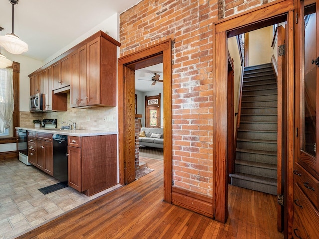 kitchen featuring tasteful backsplash, hanging light fixtures, electric range, dishwasher, and light hardwood / wood-style floors