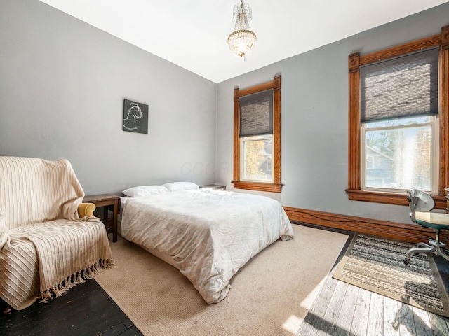 bedroom featuring hardwood / wood-style flooring and a chandelier