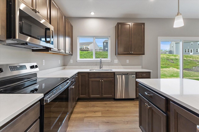 1208 Heathgate Way, Fairborn, OH 45324 - kitchen featuring appliances with stainless steel finishes, a sink, light wood-style flooring, light countertops, and dark brown cabinets