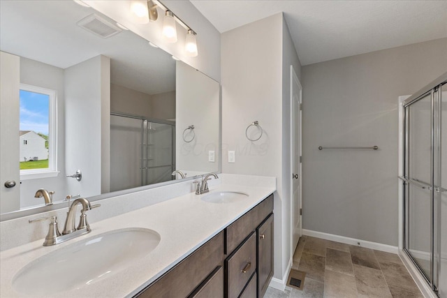 1208 Heathgate Way, Fairborn, OH 45324 - bathroom featuring a stall shower, baseboards, double vanity, and stone finish floors