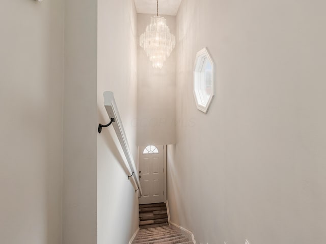 stairs featuring an inviting chandelier