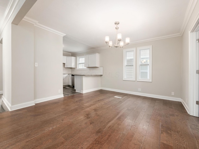 unfurnished living room with an inviting chandelier, ornamental molding, and dark hardwood / wood-style floors