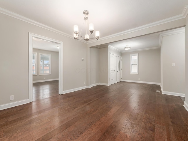 empty room with dark hardwood / wood-style flooring, a notable chandelier, and ornamental molding