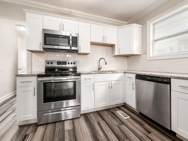 kitchen featuring light stone countertops, white cabinetry, appliances with stainless steel finishes, and sink