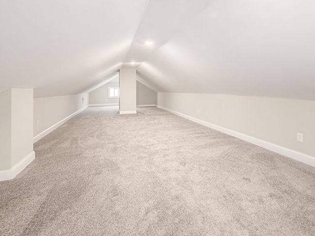 bonus room featuring vaulted ceiling and carpet