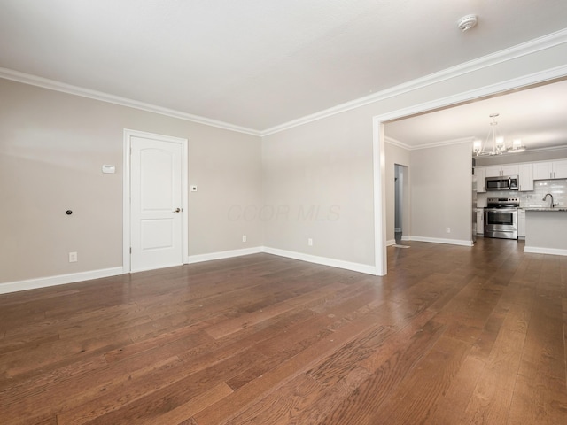 unfurnished living room with ornamental molding, dark hardwood / wood-style floors, sink, and a notable chandelier