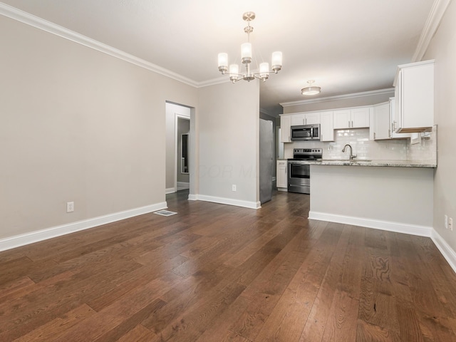 unfurnished living room with ornamental molding, dark hardwood / wood-style floors, sink, and a notable chandelier