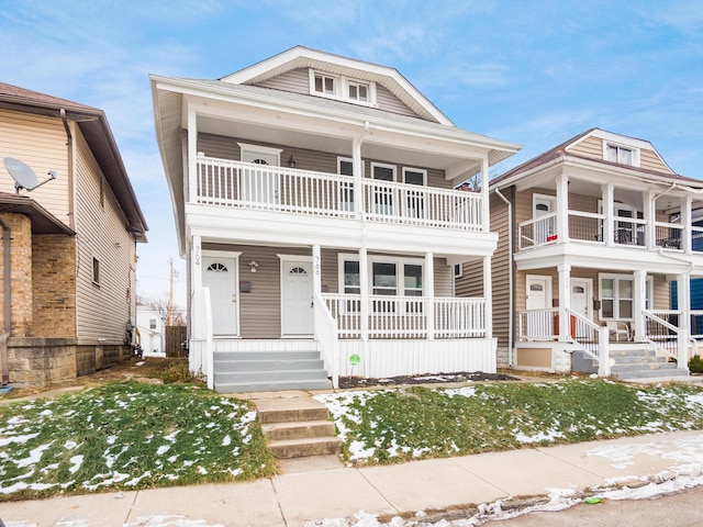 view of front of home featuring a balcony and a front lawn