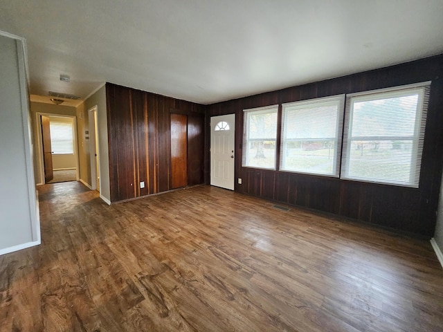 interior space with hardwood / wood-style flooring and wooden walls