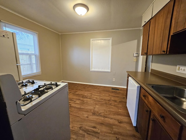 kitchen with crown molding, dark hardwood / wood-style floors, sink, and white appliances