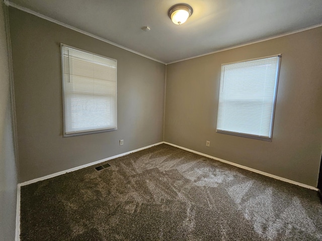 empty room with ornamental molding and carpet flooring