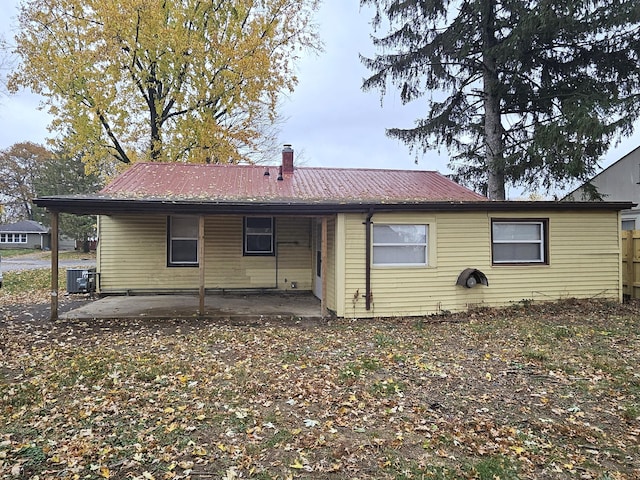 rear view of property featuring a patio and central AC