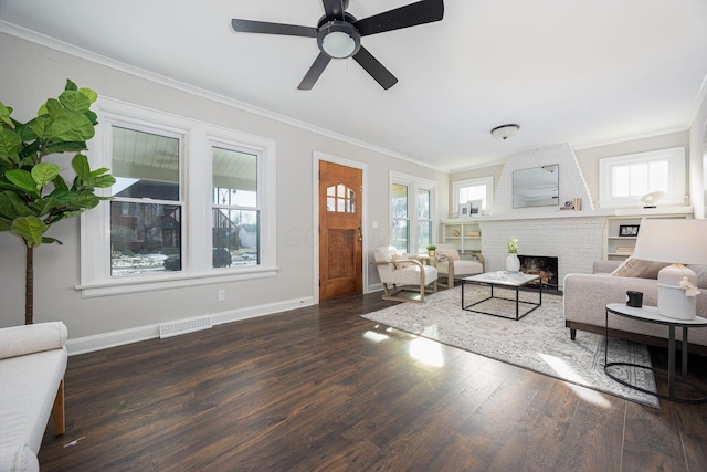 living room featuring ornamental molding, a brick fireplace, ceiling fan, and dark hardwood / wood-style flooring