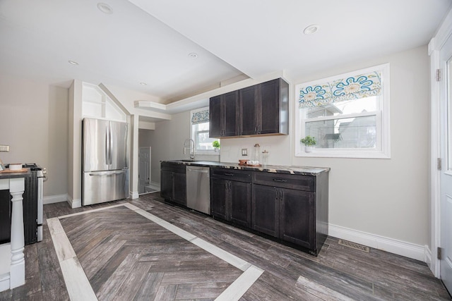 kitchen featuring appliances with stainless steel finishes, sink, dark parquet floors, and dark brown cabinets