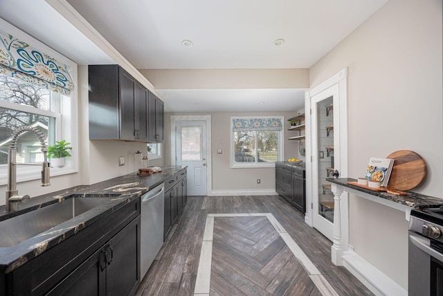 kitchen featuring sink, dark stone counters, and appliances with stainless steel finishes