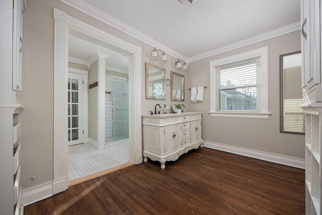 bathroom with crown molding, vanity, and hardwood / wood-style floors