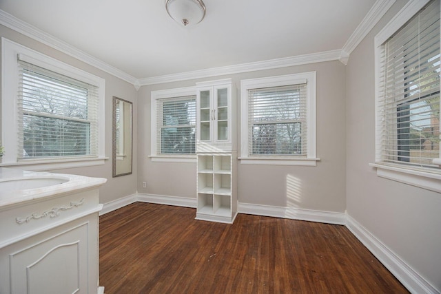 unfurnished dining area featuring crown molding, plenty of natural light, dark hardwood / wood-style floors, and sink