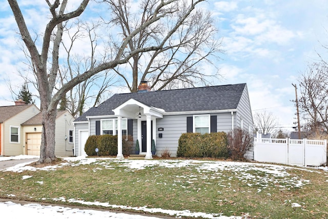 single story home featuring a garage and a lawn