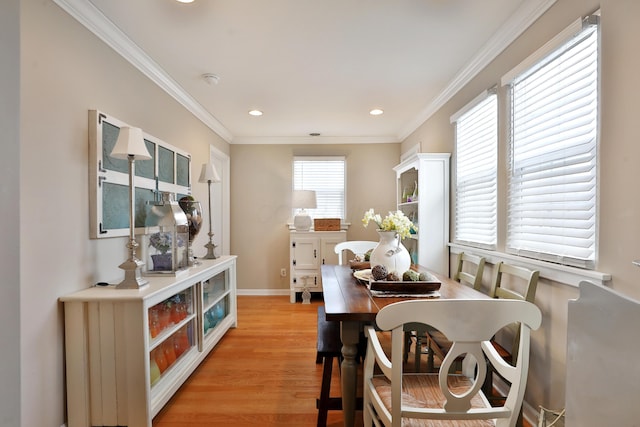 dining space with crown molding and light wood-type flooring