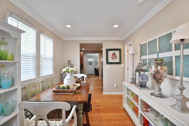 dining space with crown molding, plenty of natural light, and light hardwood / wood-style floors