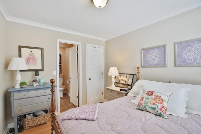 tiled bedroom with ornamental molding, a closet, and ensuite bathroom