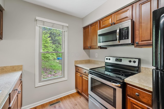 kitchen with appliances with stainless steel finishes and light wood-type flooring